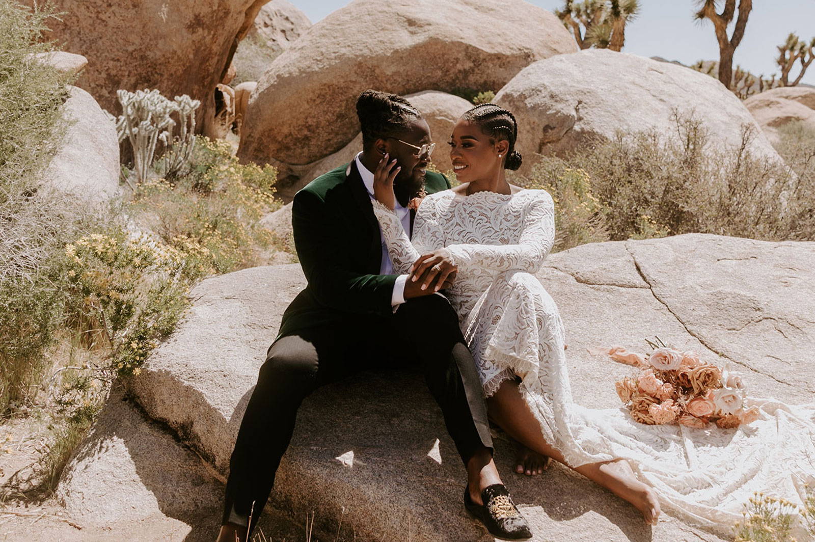 Bride and Groom sitting on rock in wedding dress