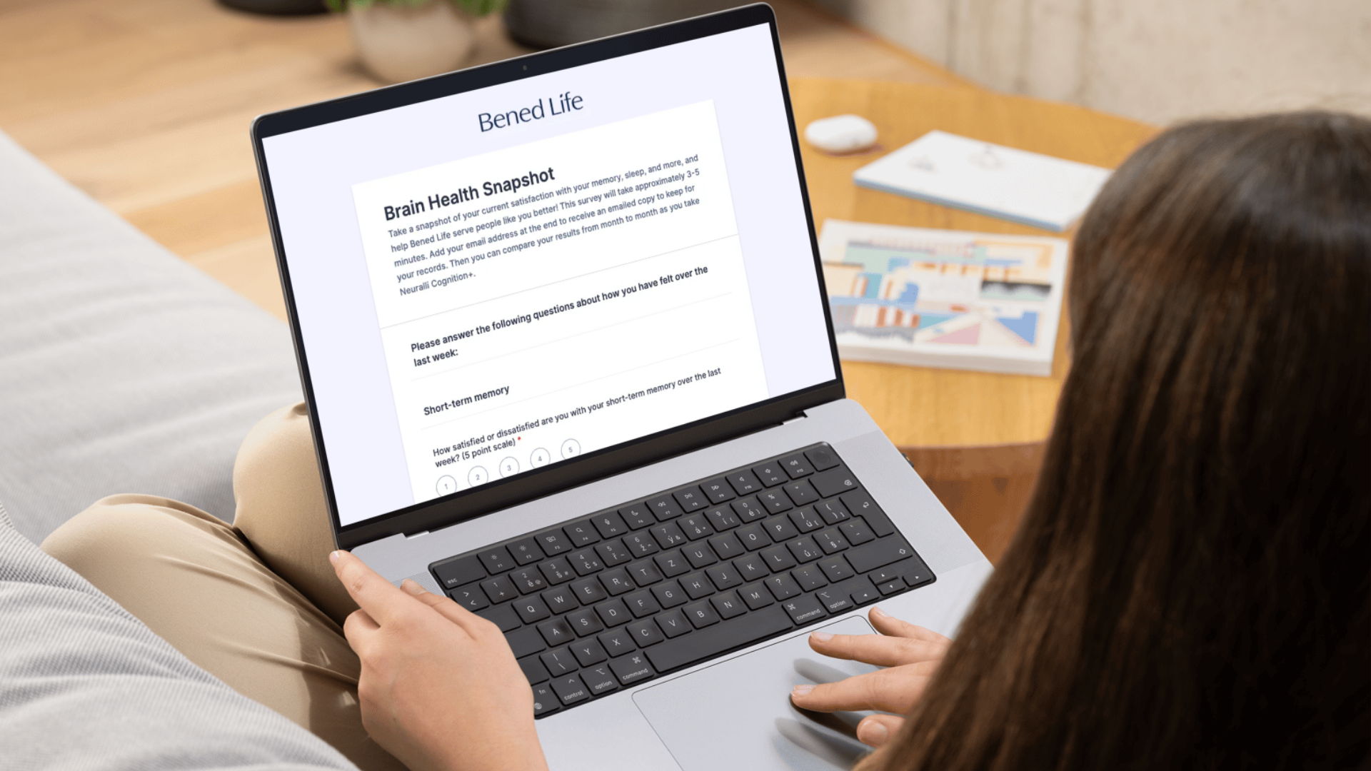 Person typing on a laptop while sitting on a couch.