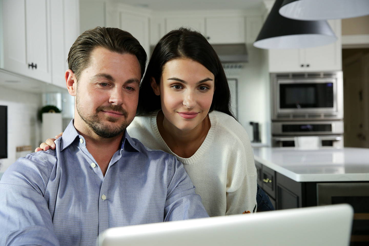 Man and woman use laptop to purchase a Tuc Blanket