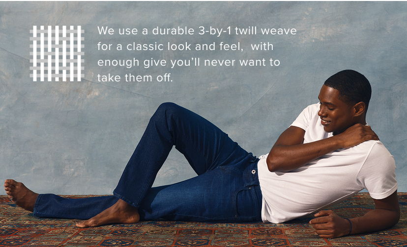 Man lying down in a casual outfit, relaxed against a textured background.