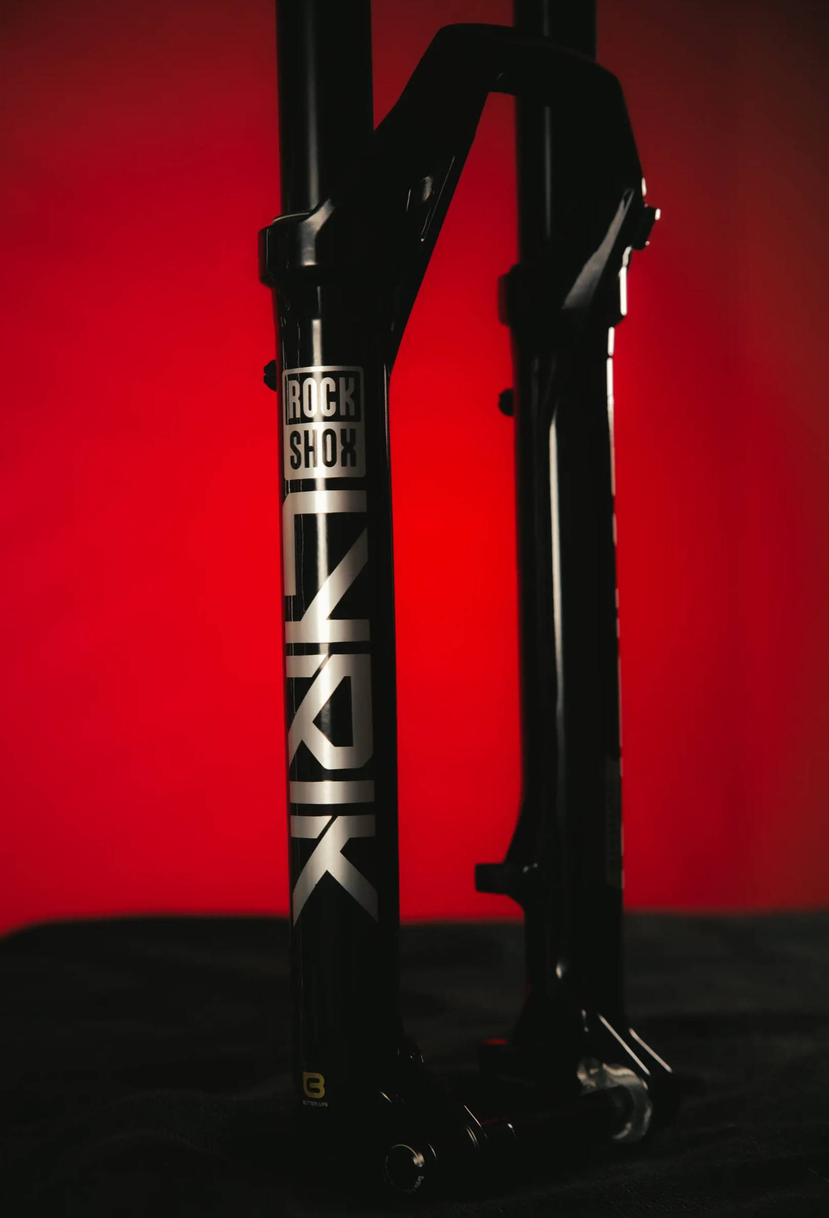 rockshox lyrik ultimate mountain bike fork in silver on a red and black background