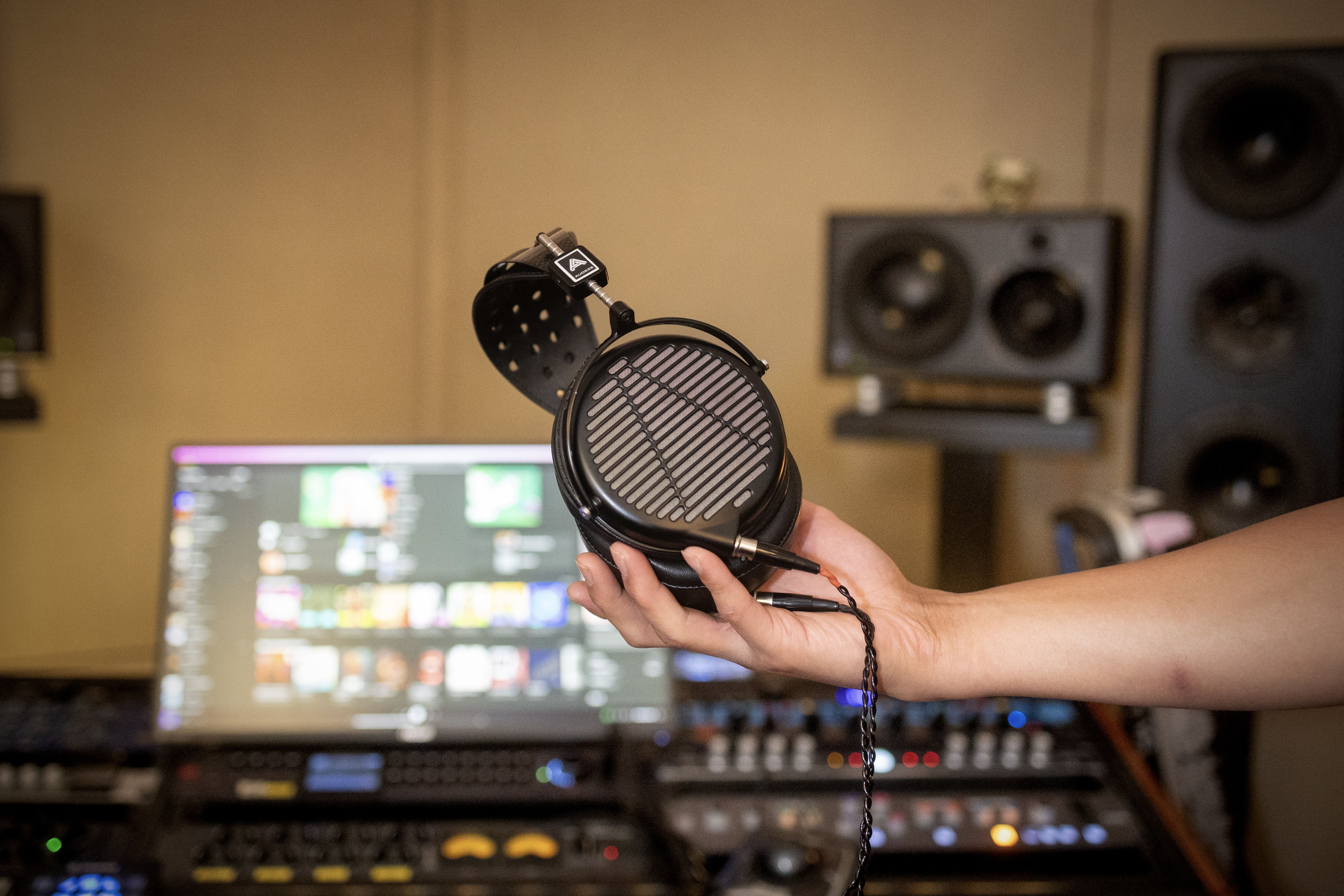 Andrew Kim holding Audeze LCD-MX4 headphones in the studio 