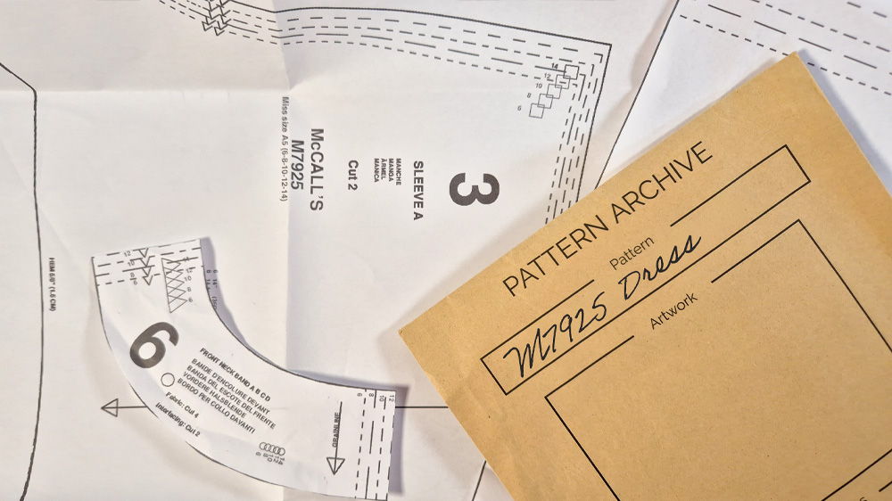 Pattern pieces and an archive folder on a table.