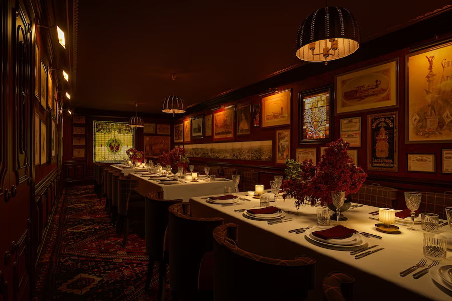 Dimly lit restaurant with a long table set for dining.