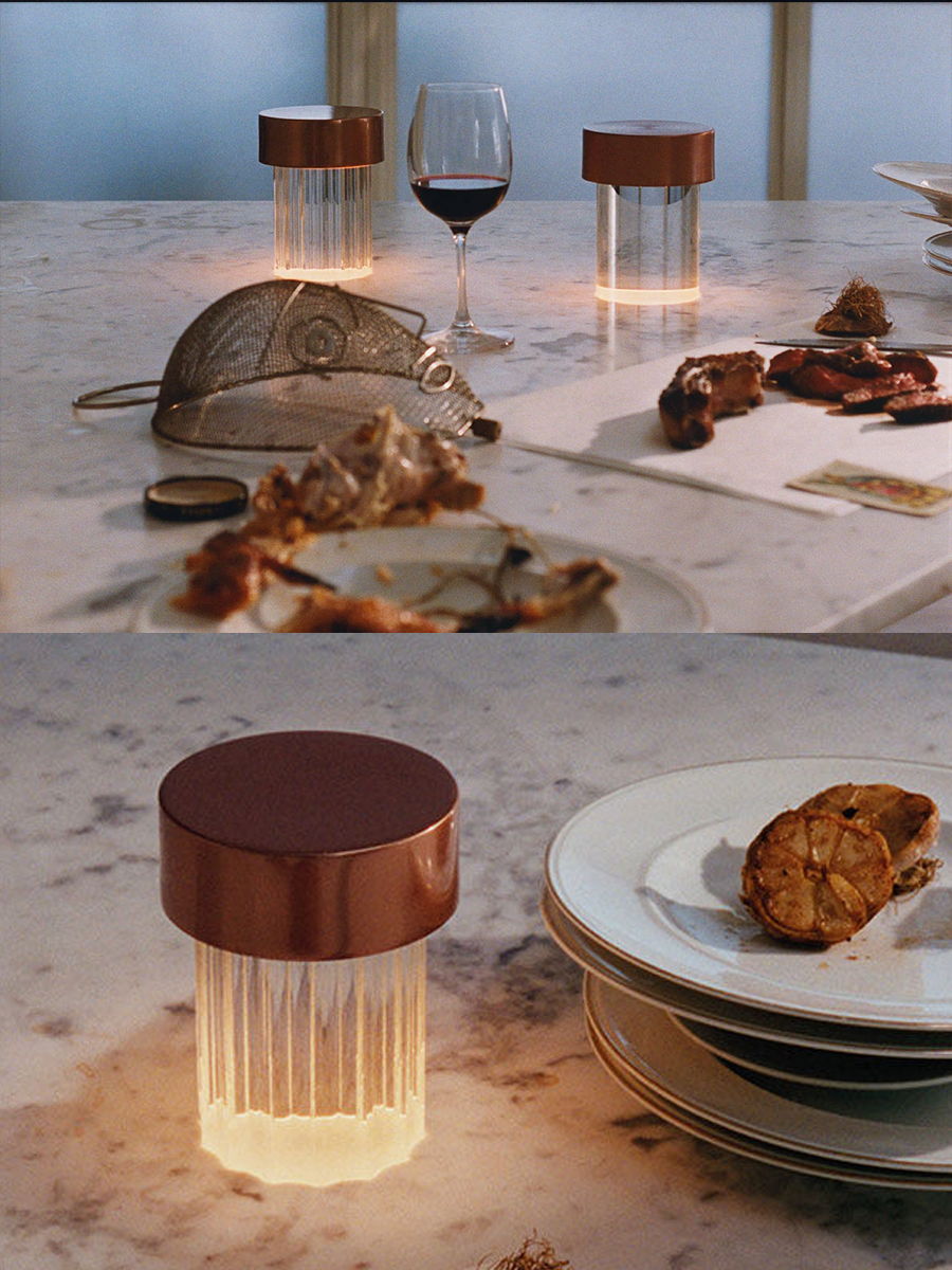 Table setting with illuminated food containers by Flos, wine glass, and plated cookies.
