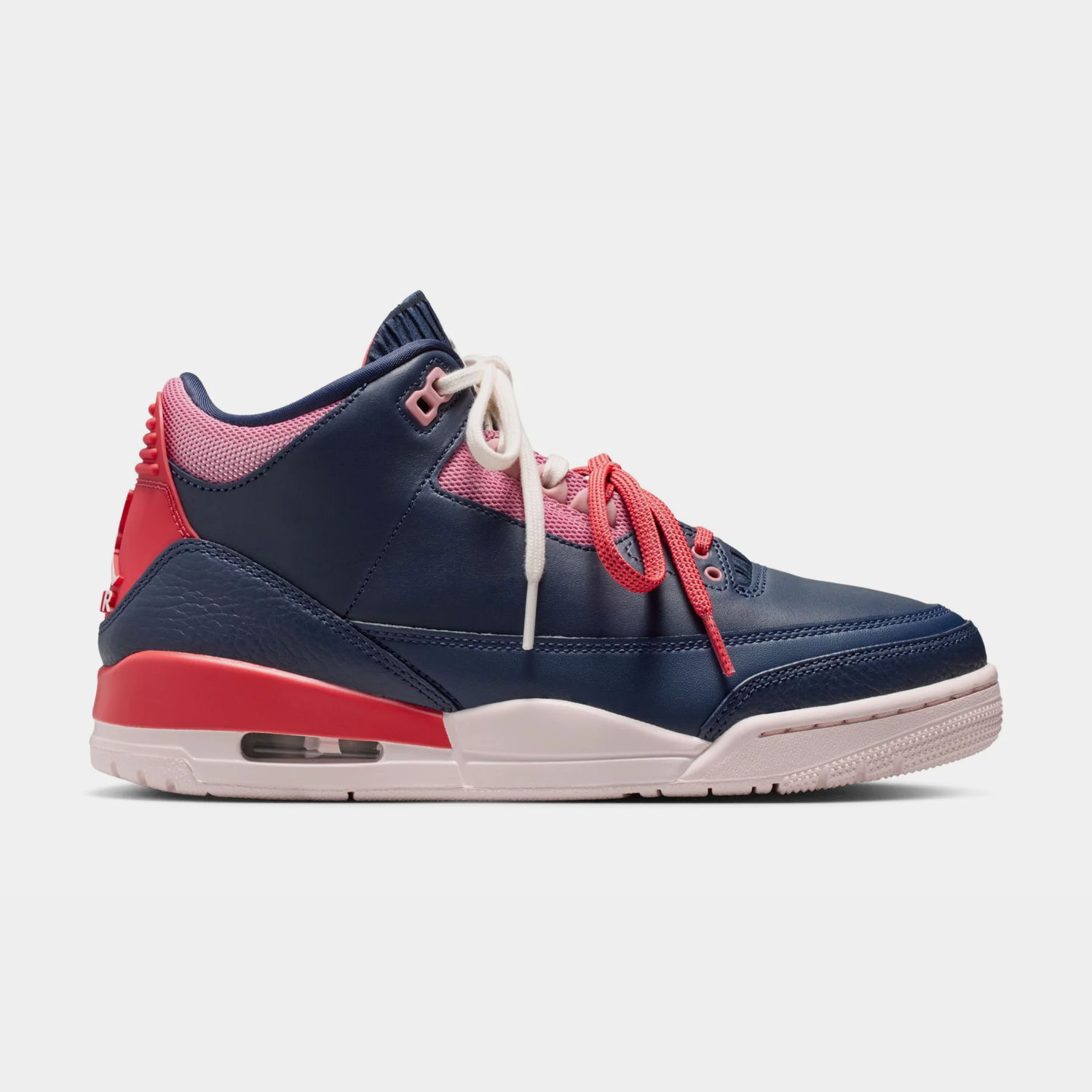 Navy and red sneaker with white laces and a pink sole.