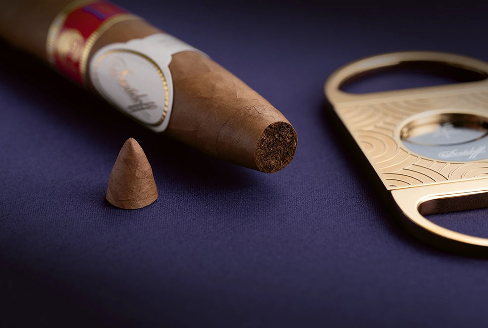 Eine angeschnittene Year of the Sheep Piramides-Zigarre neben dem Double Blade Cutter.