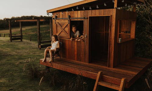 A wooden temple Farmhouse cubby with two kids