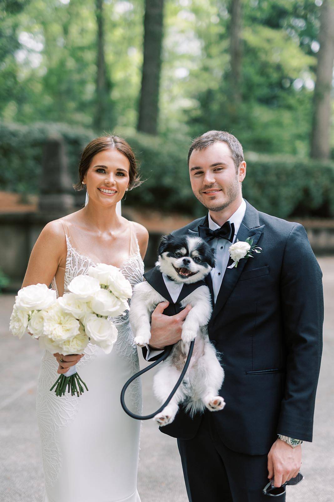 The bride and groom sharing a special moment with their furry companion on their special day.