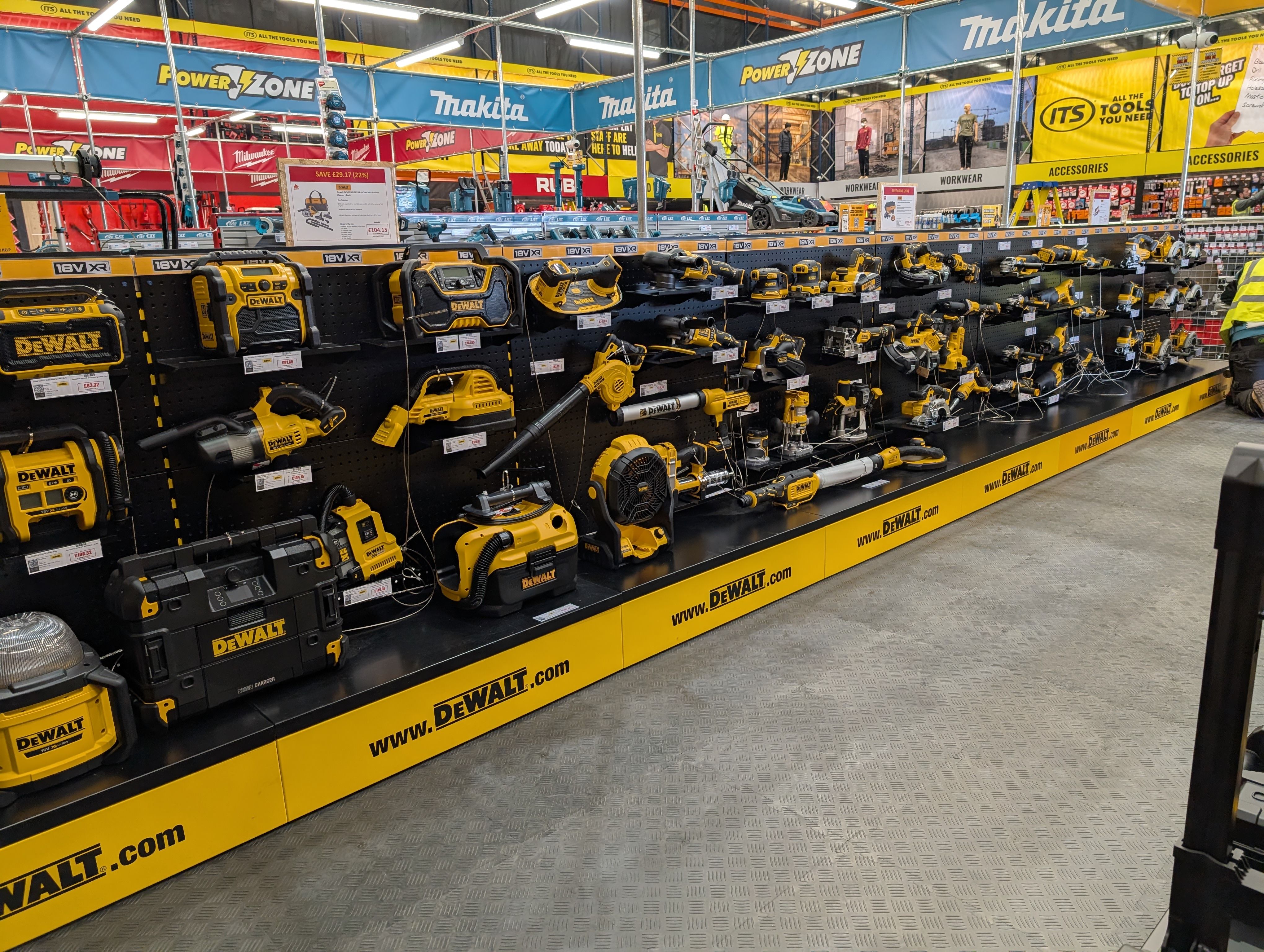 Display of yellow and black power tools in a retail store aisle.
