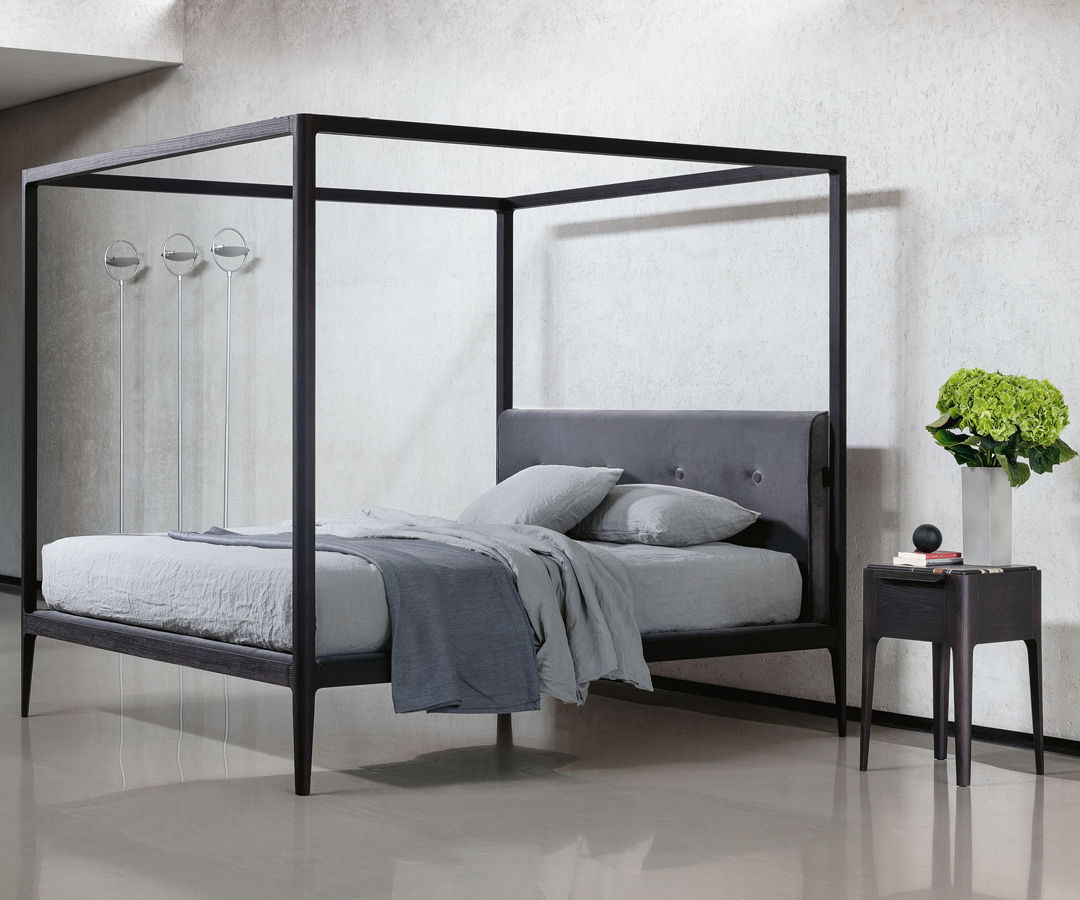 Modern four-poster Porada bed with grey bedding and a side table.