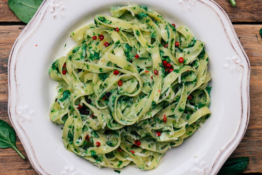 rustic plate of pasta with thick noodles and green sauce