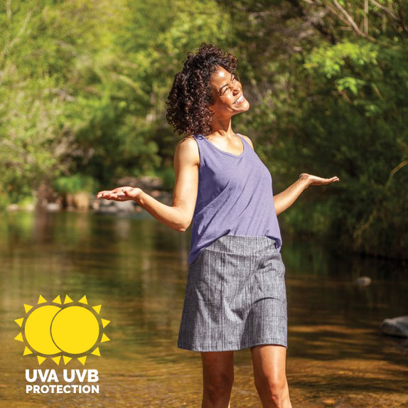 Woman standing in creek wearing UPF rated tank and skirt.