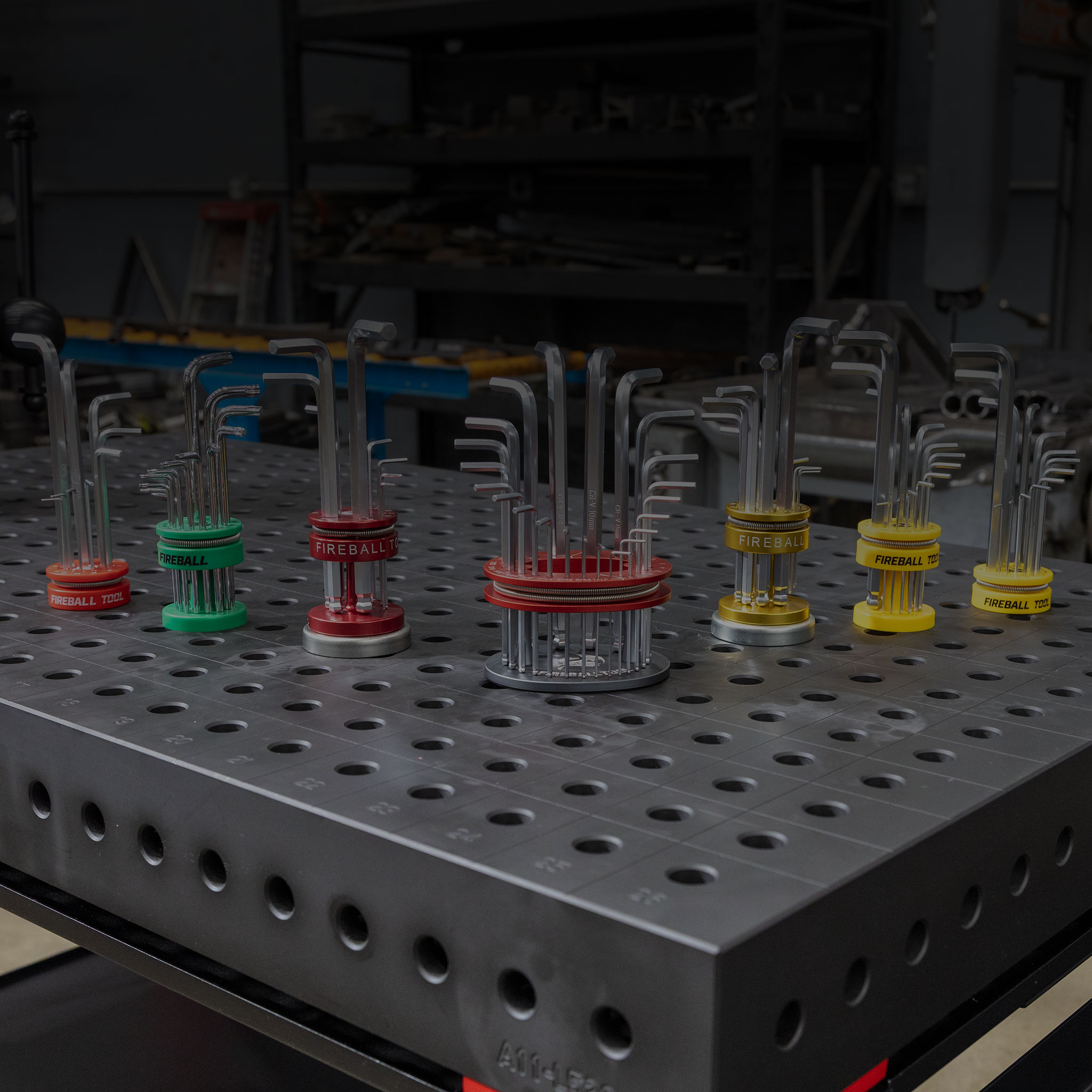 Metal workbench with various colored clamps and tools arranged on it.