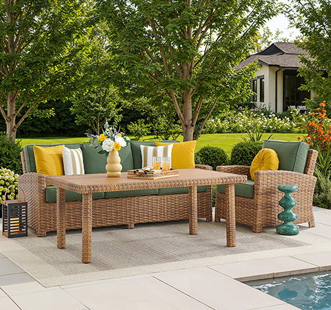 Outdoor seating area with a table, cushions, and decorative elements.
