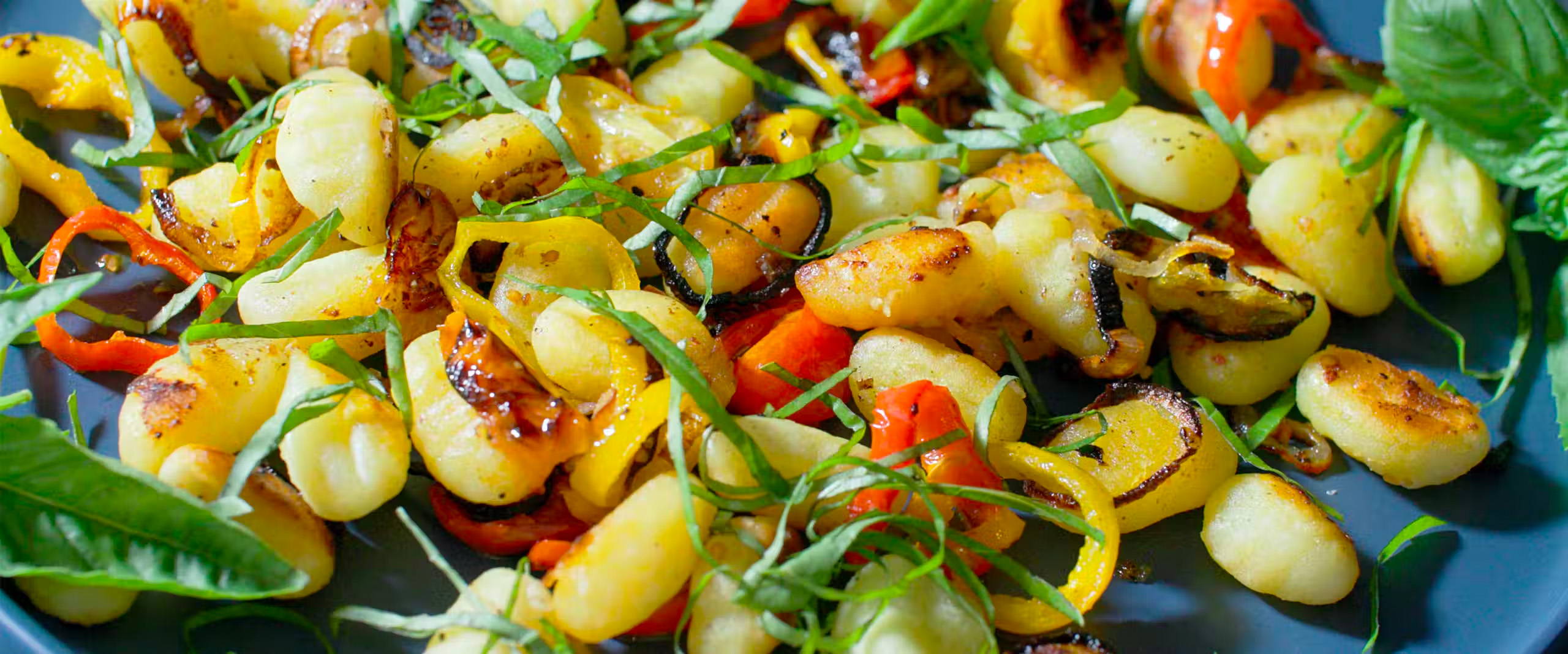 A close up picture of a plate full of crispy sheet pan gnocchi.