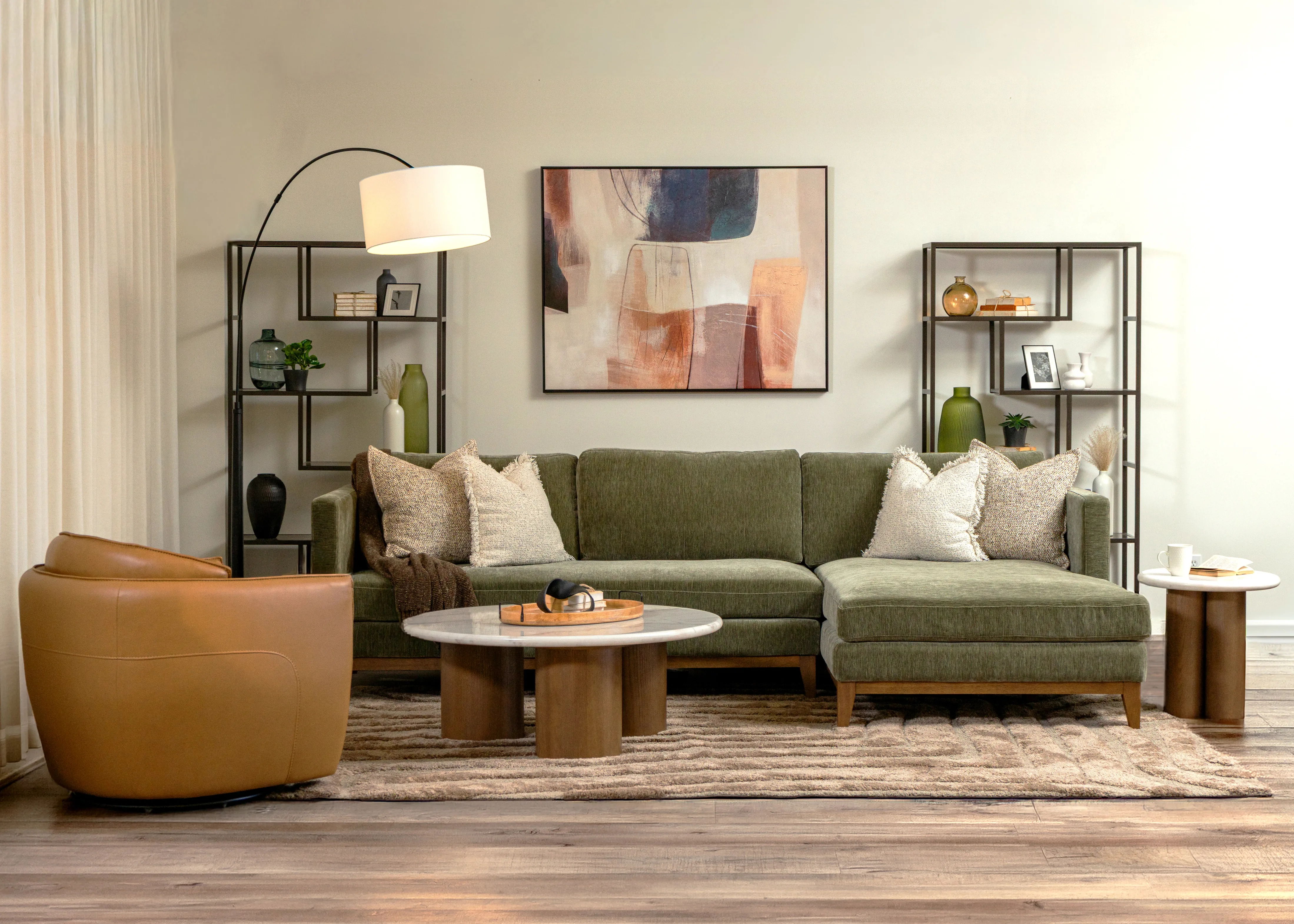 Modern living room with a green sofa, coffee table, and decorative shelves.
