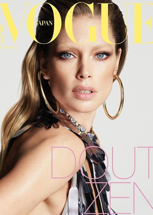 Model posing for Vogue Japan cover, wearing large hoop earrings and glamorous makeup.