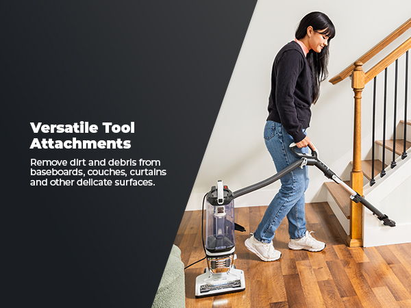 Person using a vacuum cleaner on stairs with tool attachments.