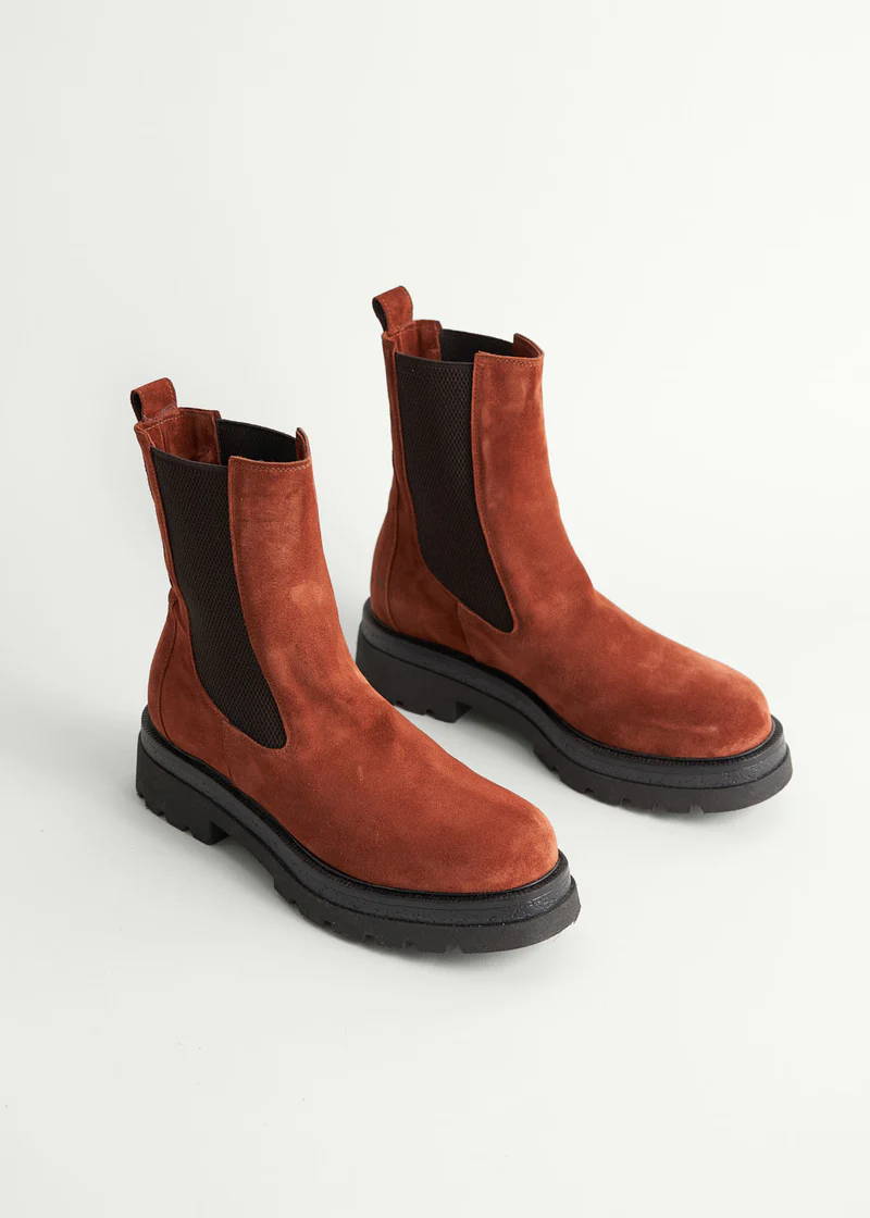 A pair of rust coloured, suede, high top, chunky chelsea boots