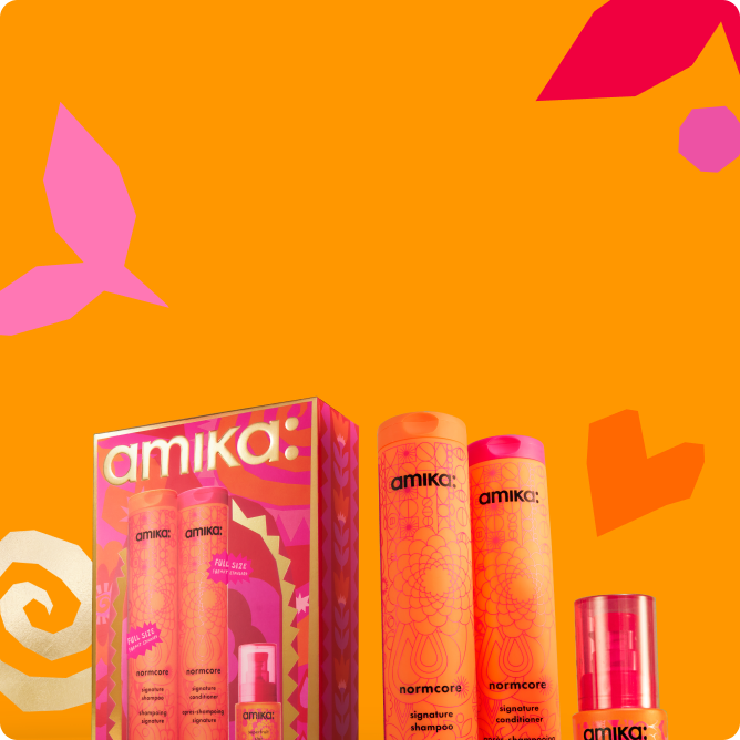 Amika hair care products with colorful packaging against an orange background.
