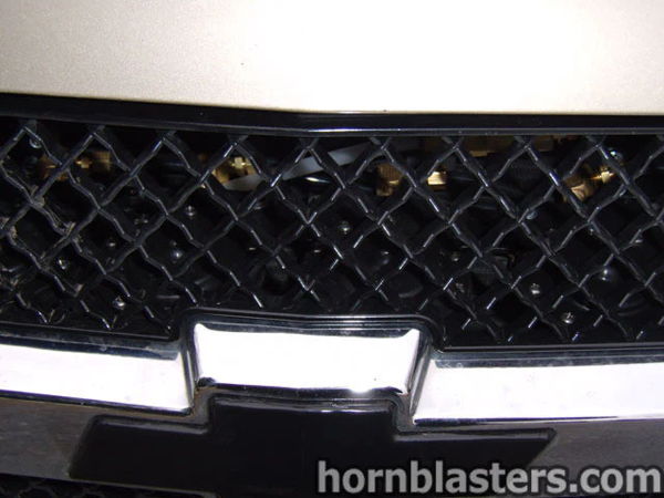 Close-up brass air lines and fittings mounted behind Joe's Silverado grille photo 3