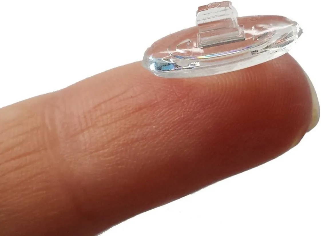 A push in a transparent nose pad for eyeglasses rested on a finger