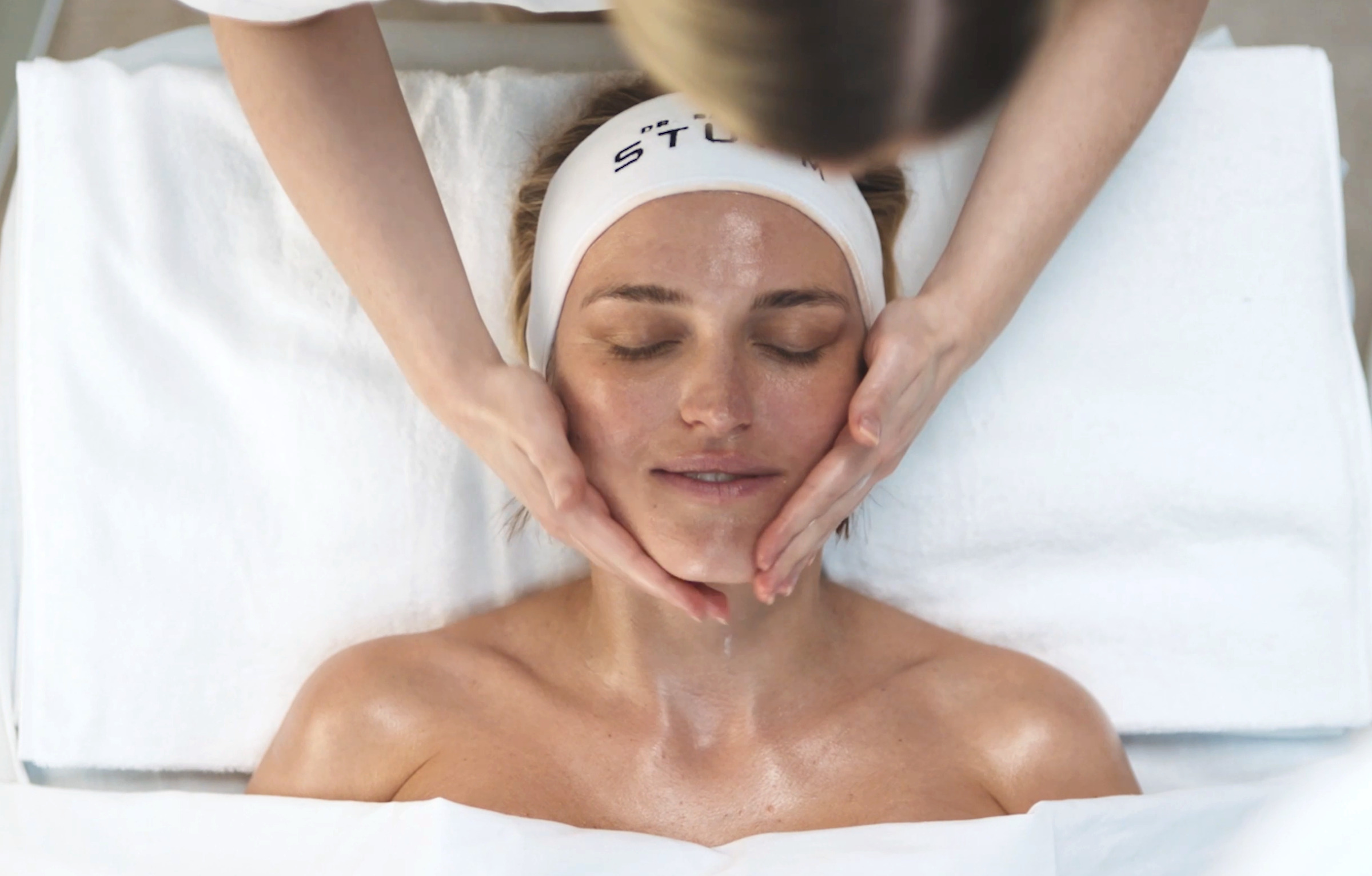 Woman receiving a facial massage in a spa setting.