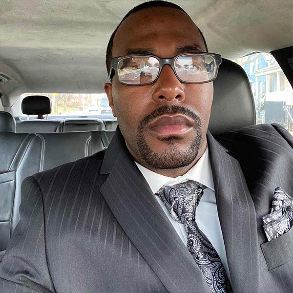 Man wearing a black paisley tie and pocket square with gray suit