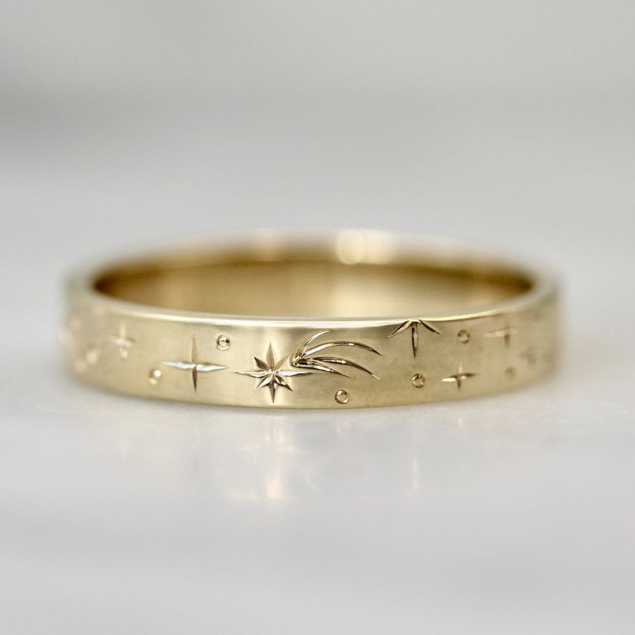Hand-engraved wedding band with shooting stars, planets, and sun rays