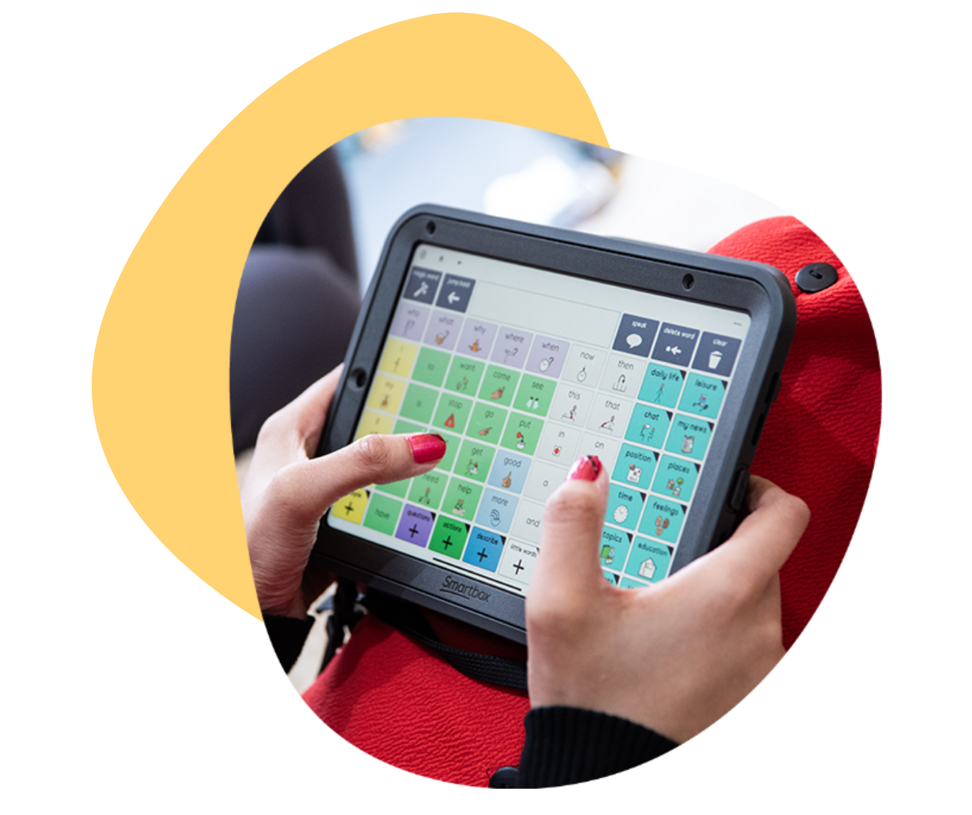 Person holding a tablet with colorful communication symbols on the screen.