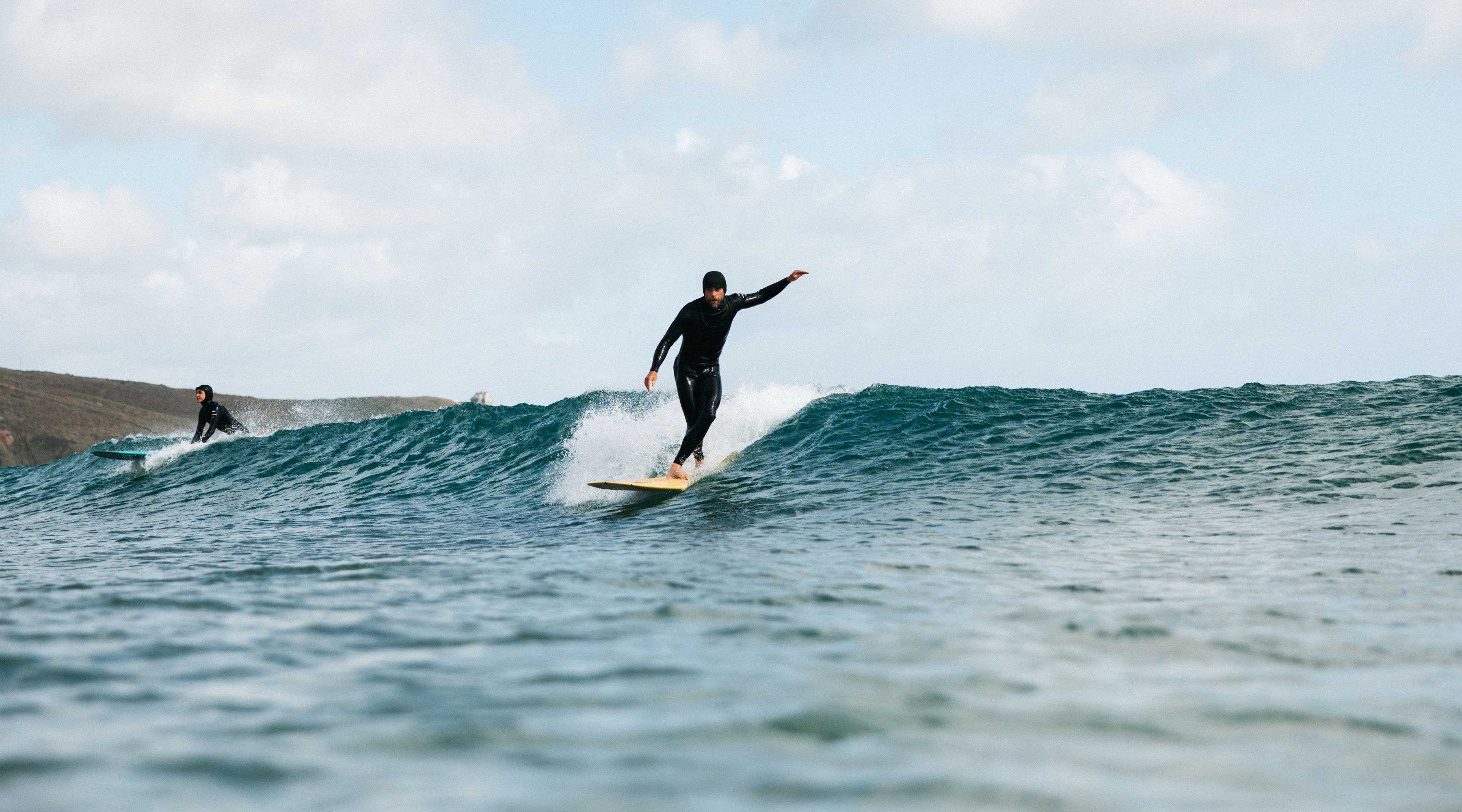 Surfer riding a wave on a sunny day.