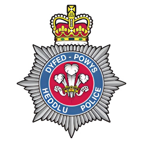 Dyfed-Powys Police badge featuring a crown and Welsh dragon.