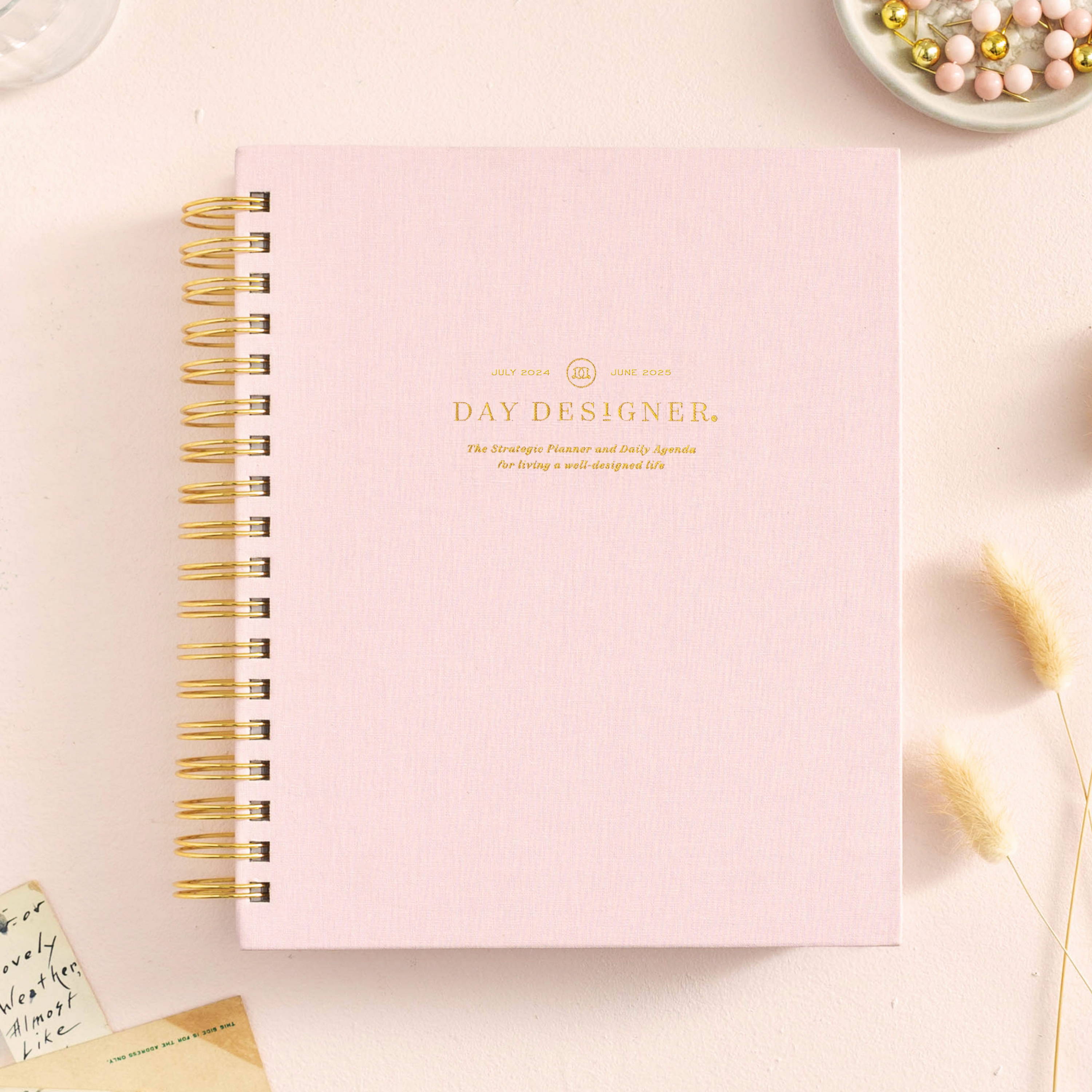 Blush pink daily closed book planner on beige background