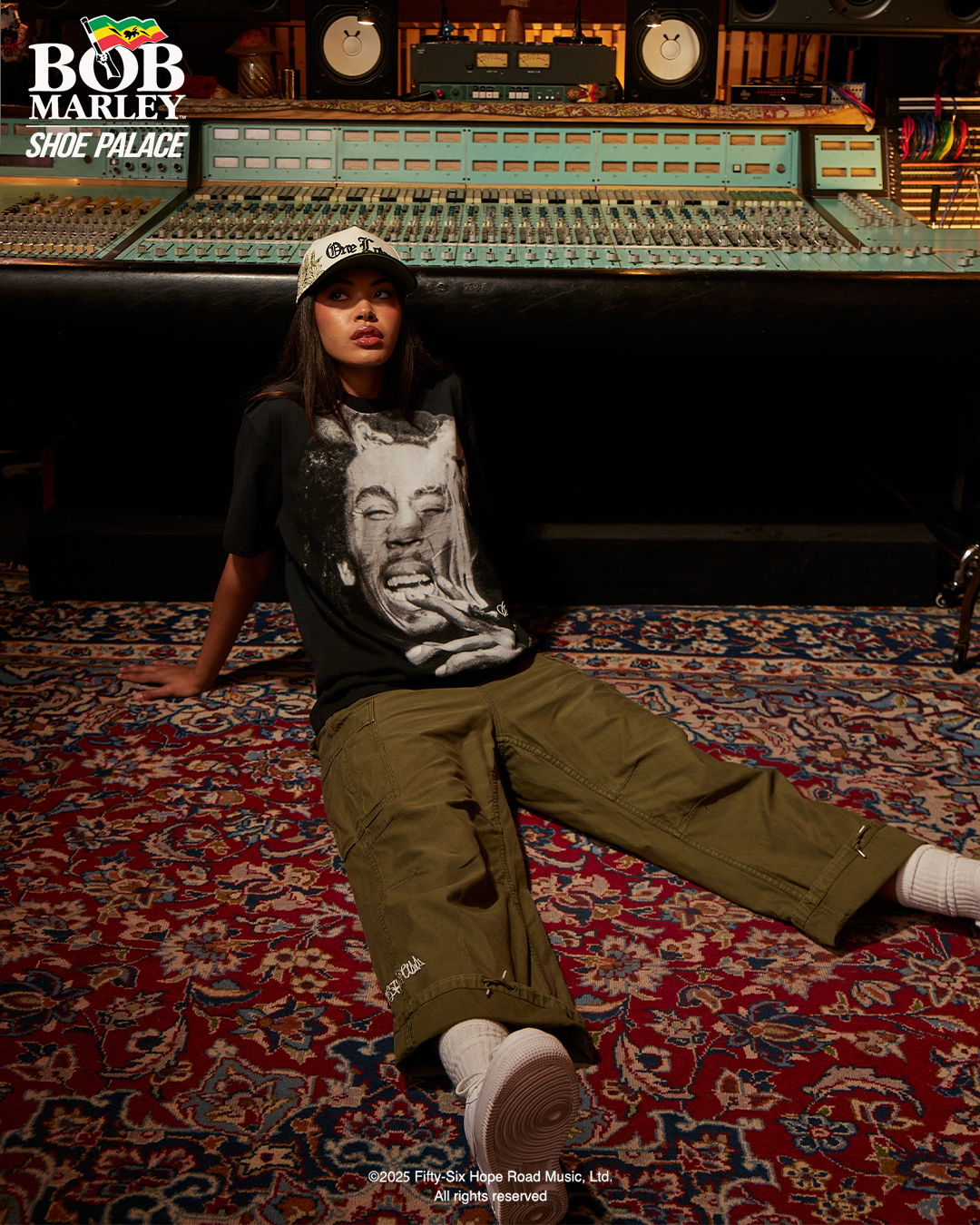A person sitting on a rug in a recording studio.