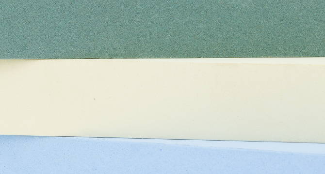 A close up of stacked green, cream, and blue sharpening stones showing high-quality finish on each.