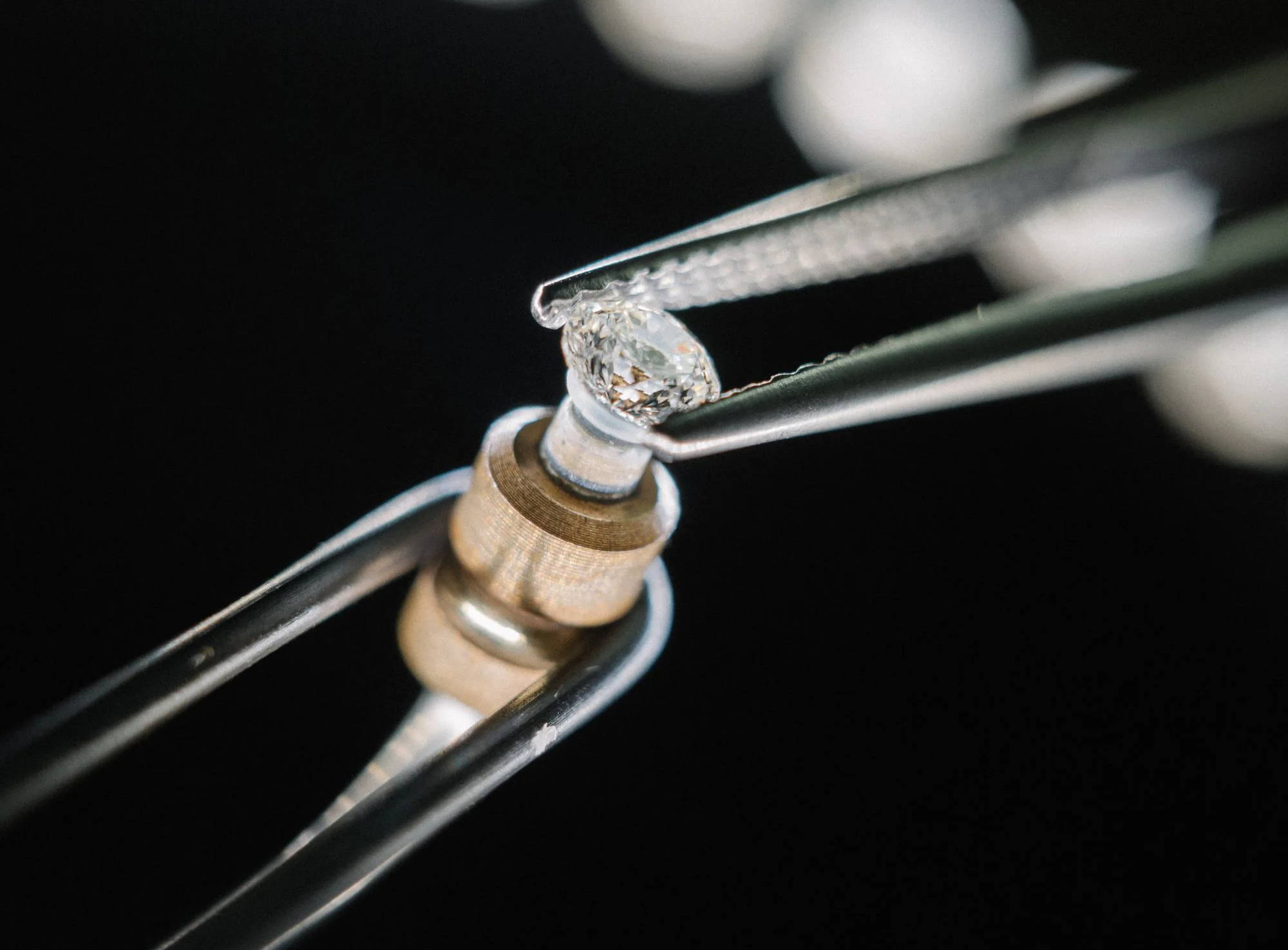 loose diamond being held by tweezers
