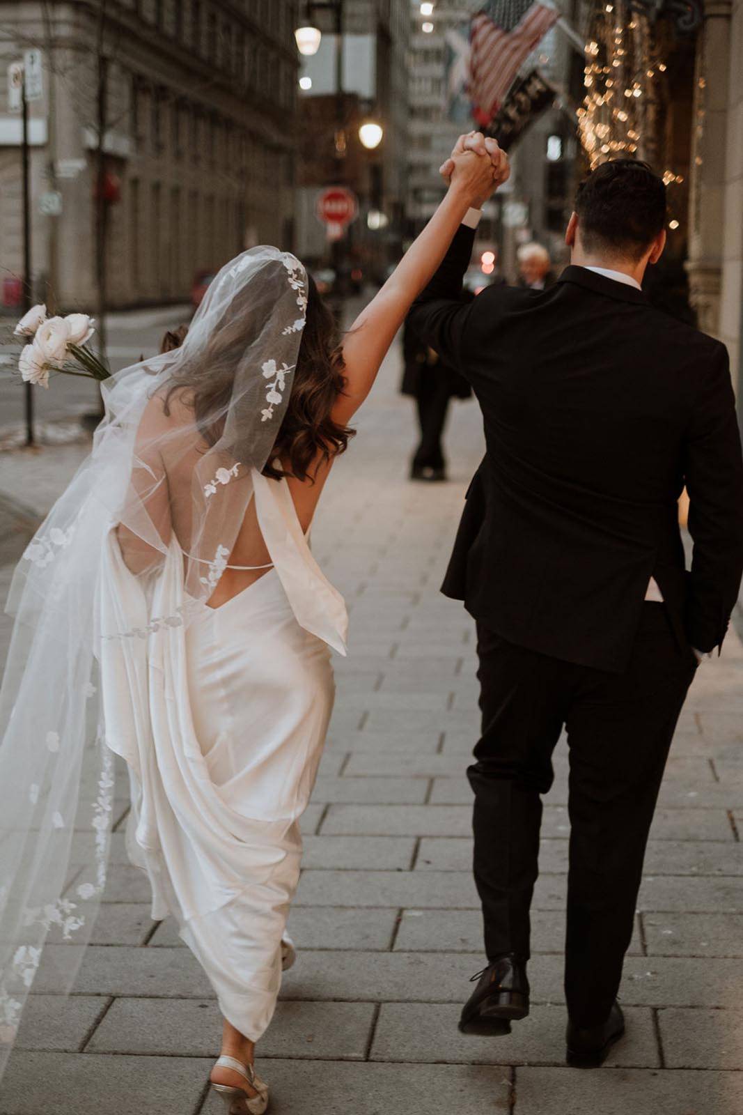 Bride and groom walking through city