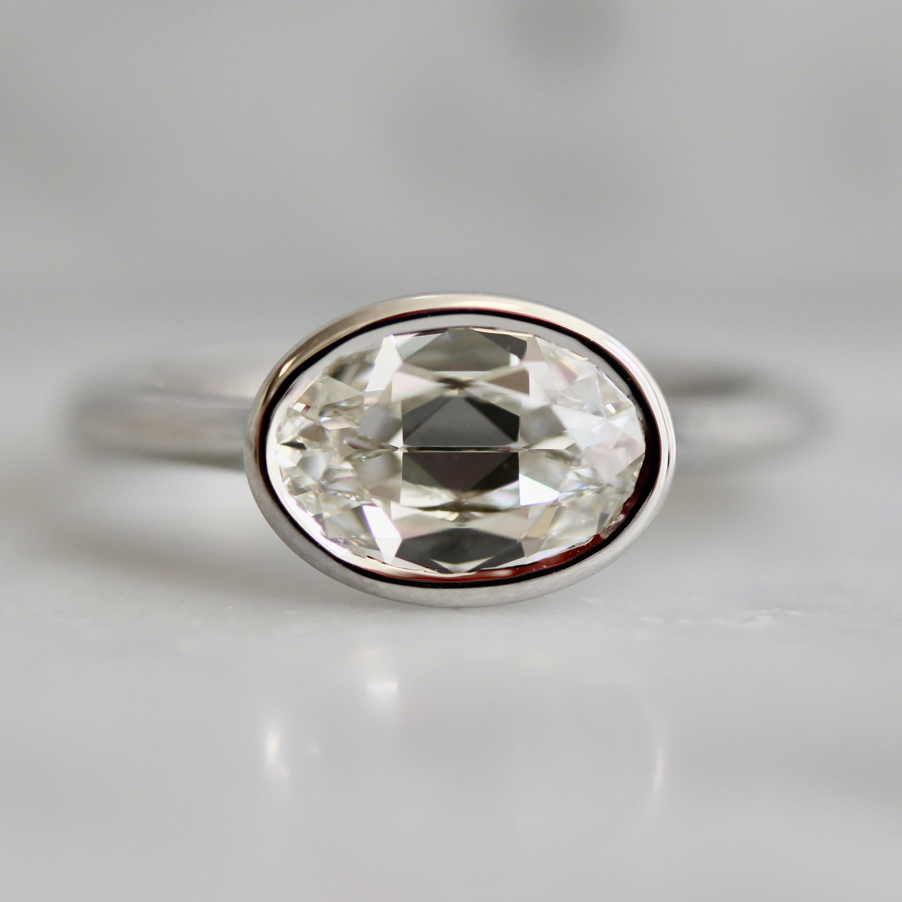 Oval cut diamond in white gold east-west bezel setting 