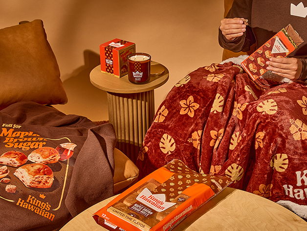 Cozy setting with snacks, blanket, and hot chocolate on a table.
