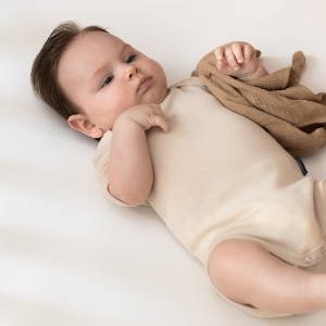 4 month old baby wearing deluxe merino short sleeve bodysuit - almond