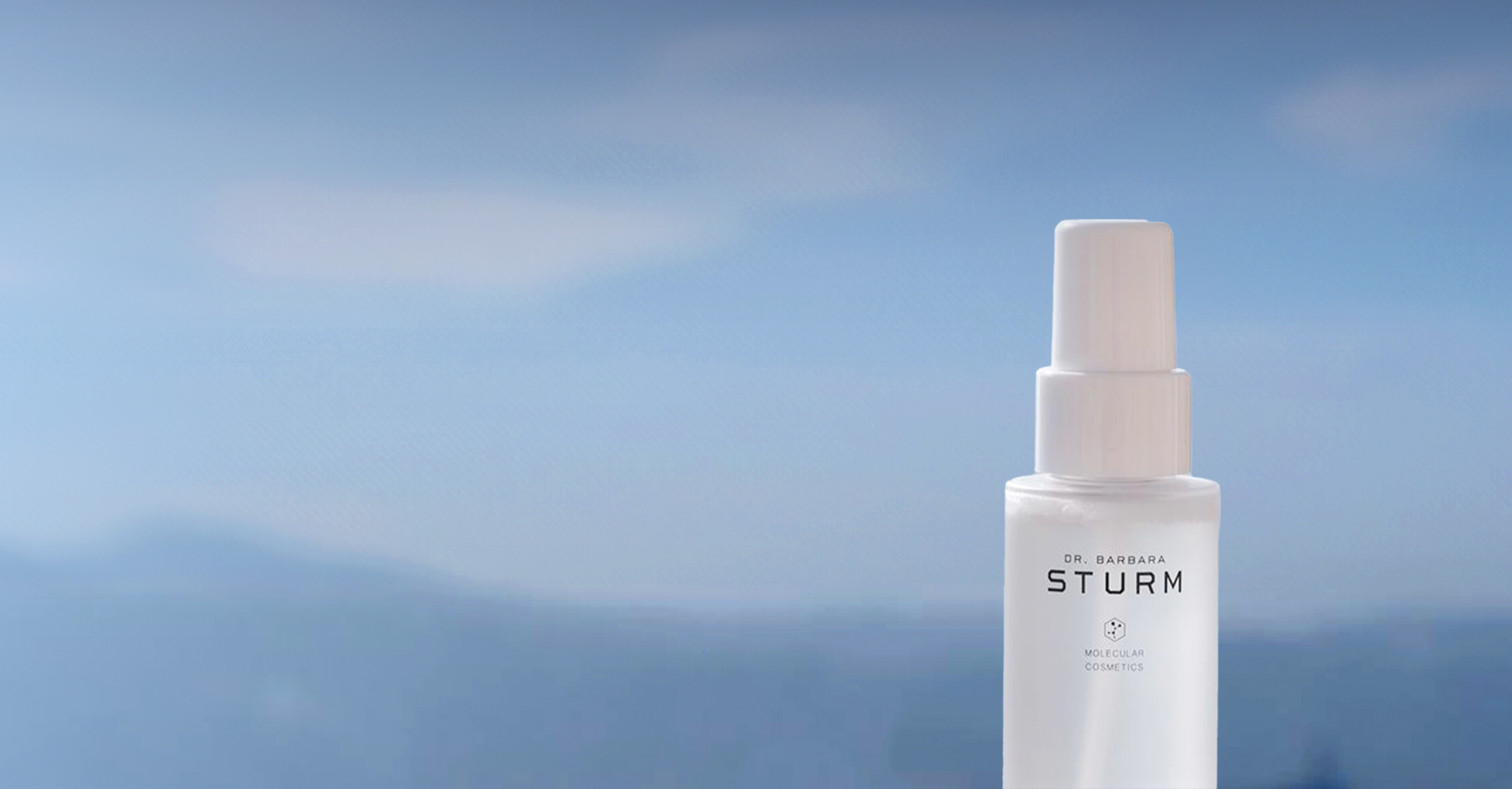 A bottle of skincare serum against a blue sky background.