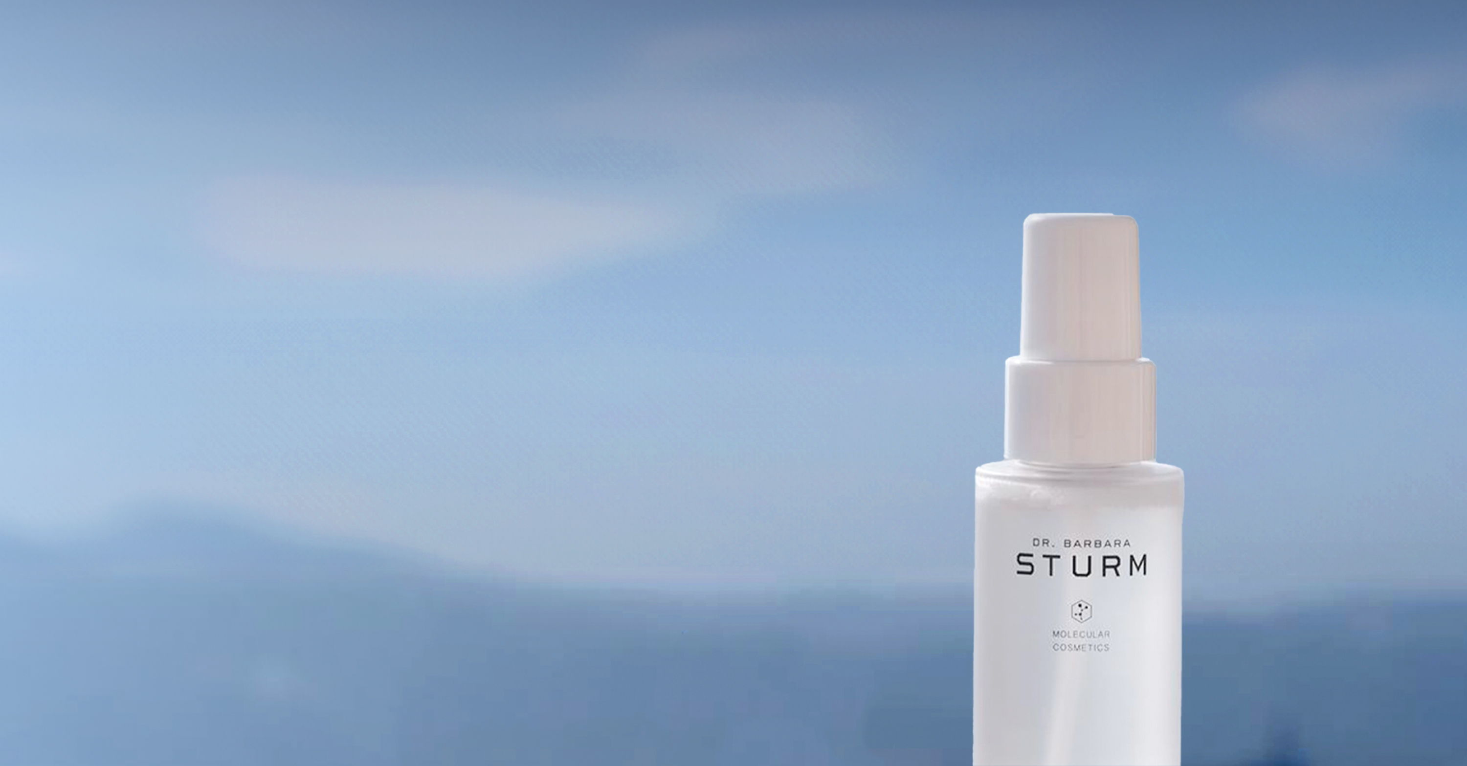 A bottle of skincare serum against a blue sky background.