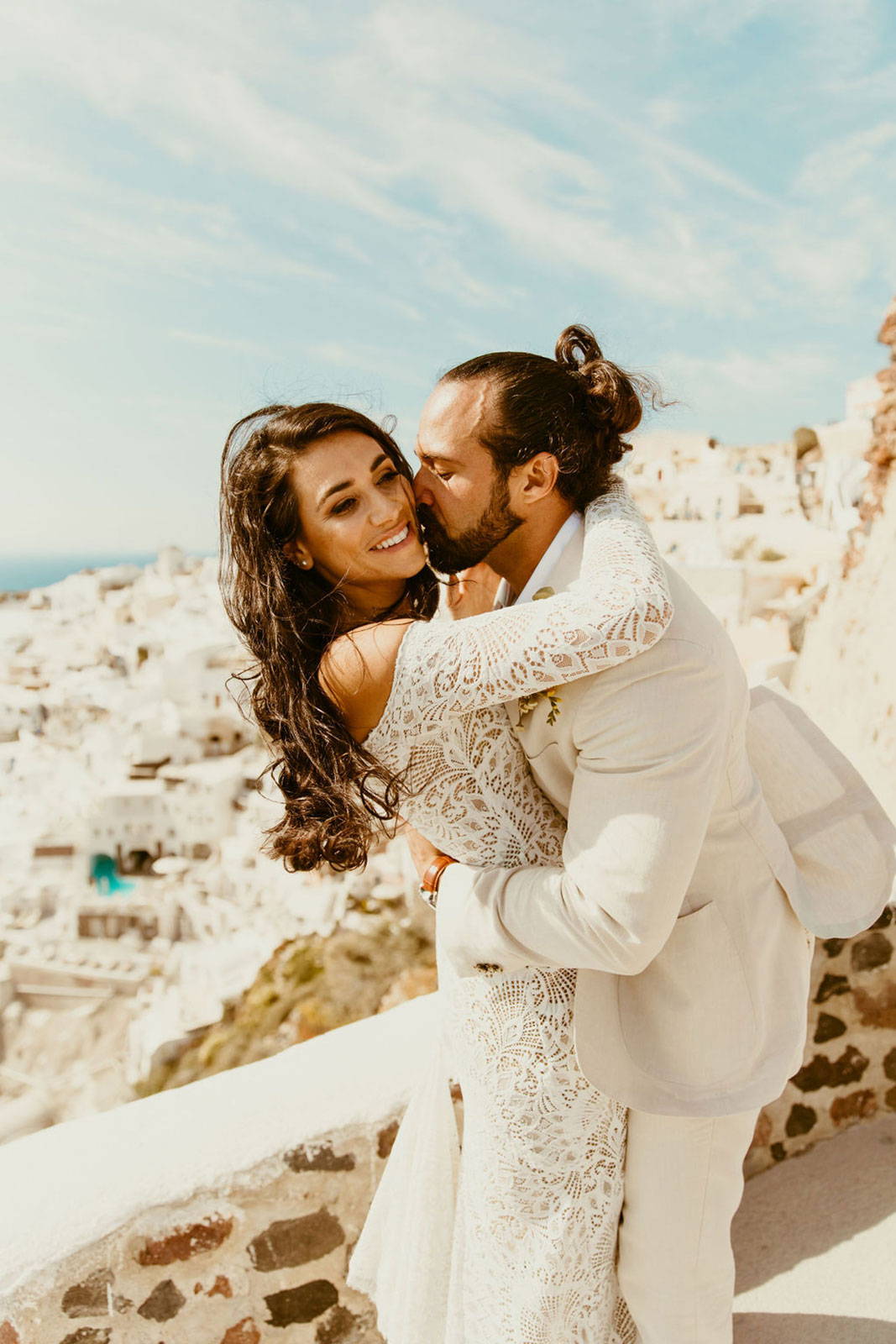 Novios con la costa de Santorini de fondo