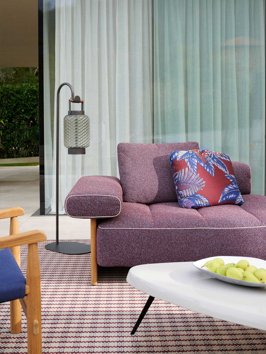 Modern outdoor seating area with a purple couch and decorative pillow.
