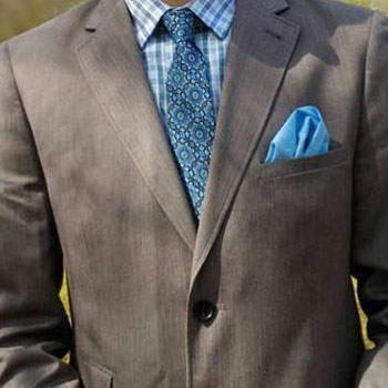 Customer wearig a blue pattern tie and a pocket square