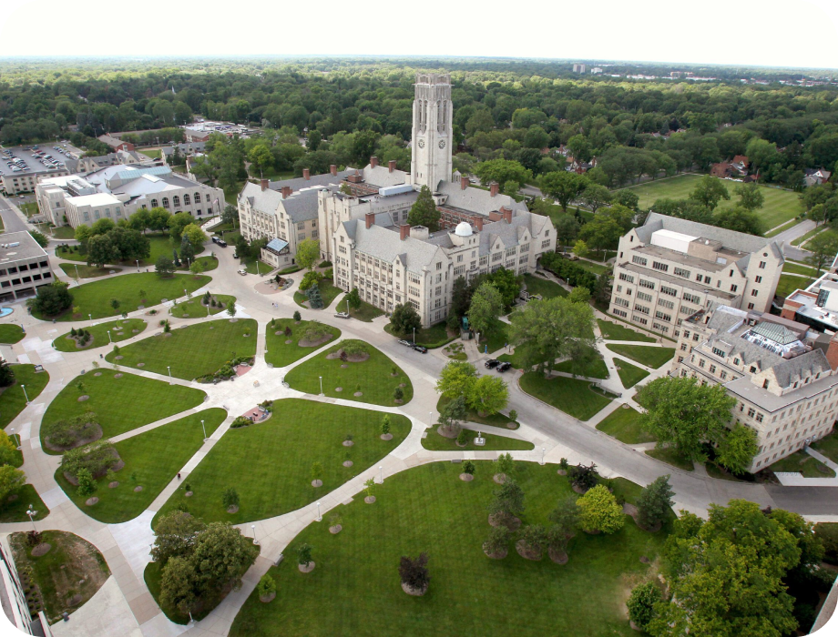 Aerial view of a university campus with green lawns and buildings.