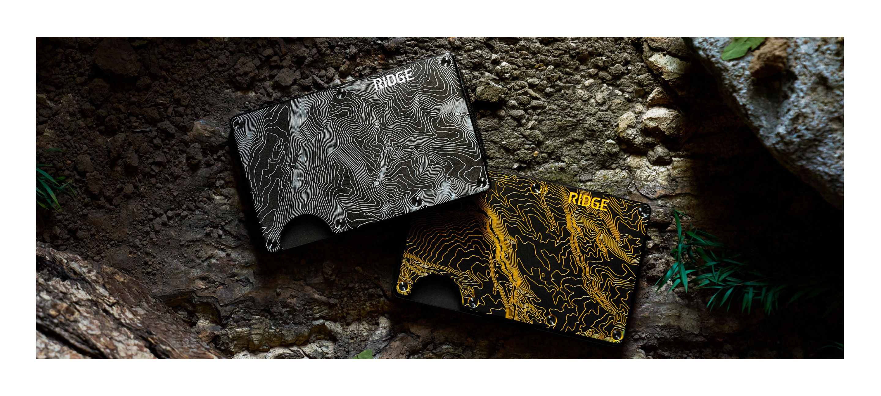 Two textured cards, one black and one yellow, resting on a rocky surface.