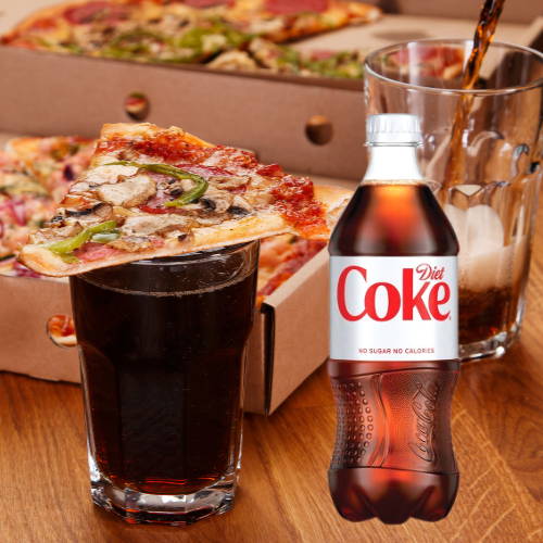 A glass of diet coke with pizza on top