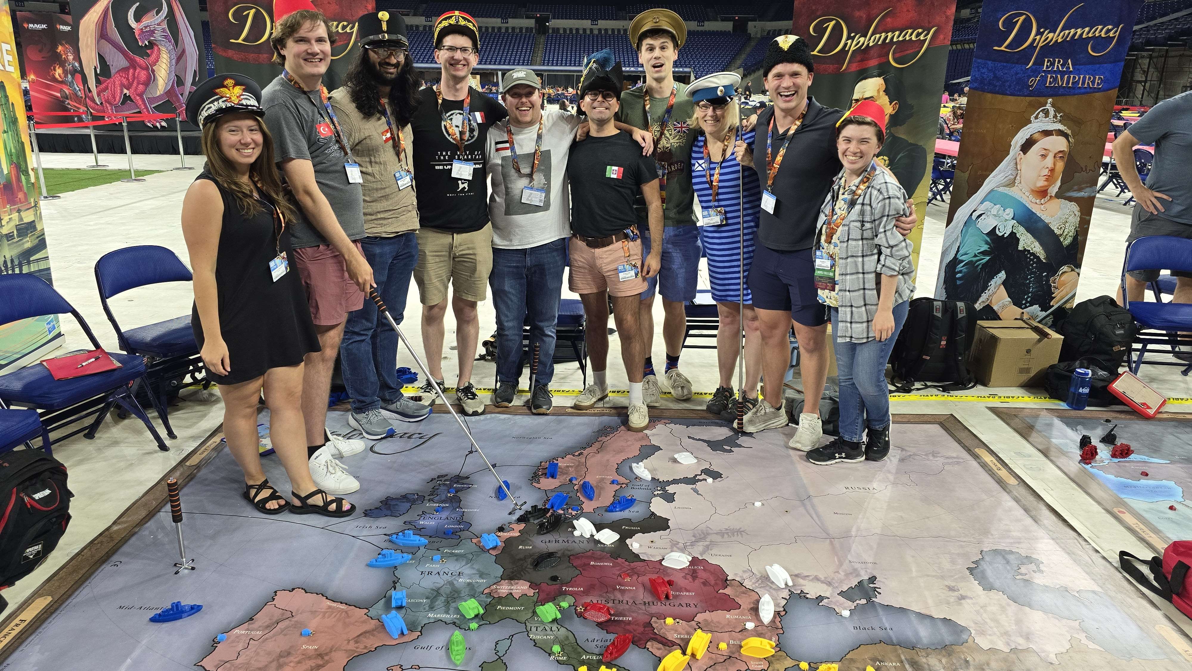 Group of people posing together at a gaming event with a game board.